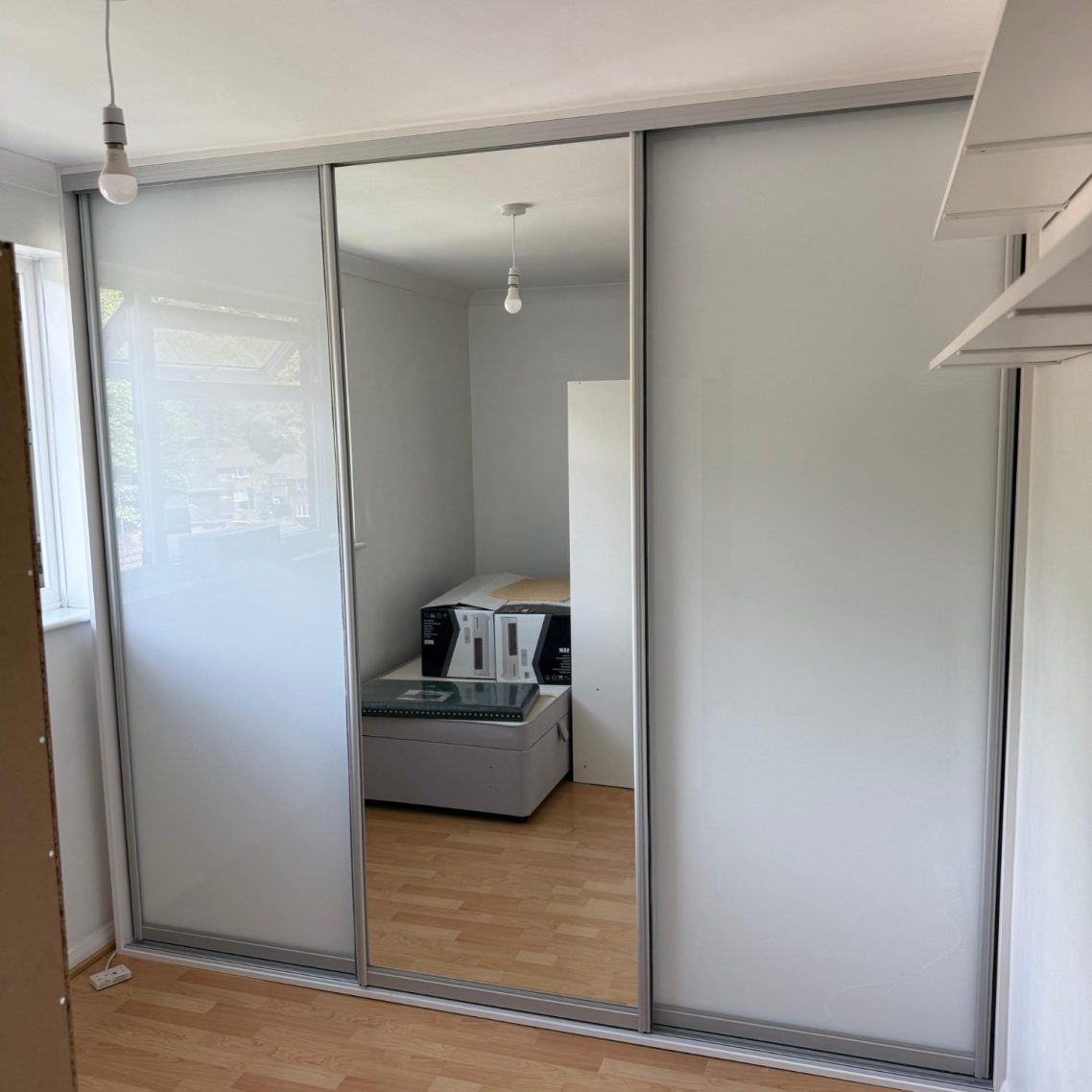 Bespoke fitted sliding wardrobe with double hanging, long hanging and fitted shelving.